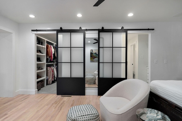12451 State Highway 174, Billings, MO 65610 - bedroom featuring a barn door, wood finished floors, a spacious closet, a closet, and recessed lighting