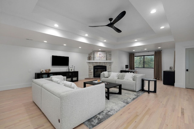 12451 State Highway 174, Billings, MO 65610 - living area featuring a tray ceiling, light wood finished floors, ceiling fan, recessed lighting, and a stone fireplace