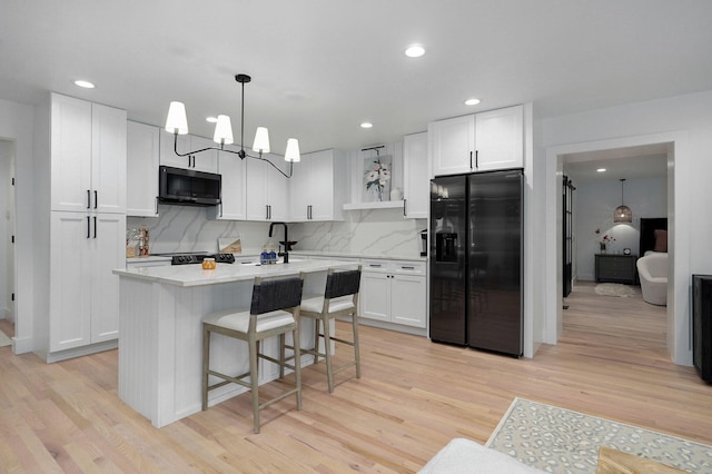 12451 State Highway 174, Billings, MO 65610 - kitchen featuring black fridge, light wood finished floors, white cabinets, light countertops, and recessed lighting