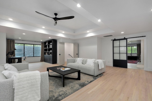 12451 State Highway 174, Billings, MO 65610 - living area with a barn door, ceiling fan, light wood-style floors, a tray ceiling, and recessed lighting