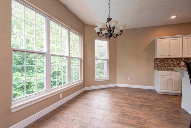 1108 N 18th Ave, Ozark, MO 65721 - unfurnished dining area featuring a chandelier, healthy amount of natural light, a textured ceiling, wood finished floors, and recessed lighting