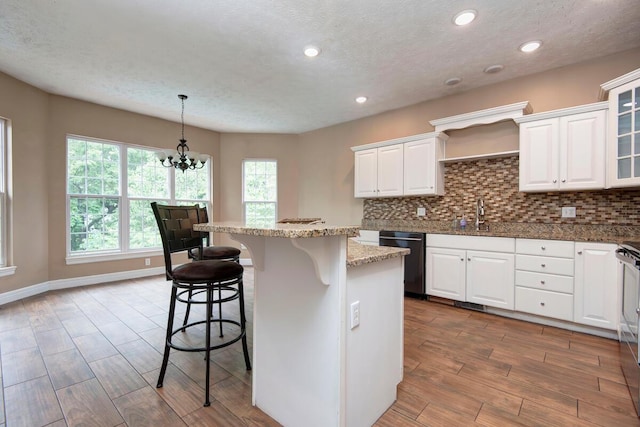 1108 N 18th Ave, Ozark, MO 65721 - kitchen featuring dishwasher, a breakfast bar, white cabinets, dark wood-style floors, and a kitchen island