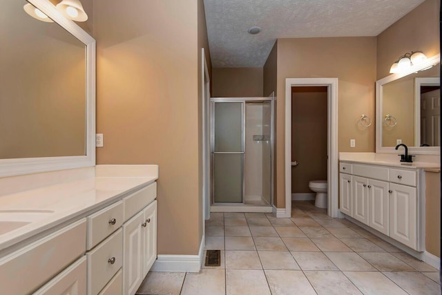 1108 N 18th Ave, Ozark, MO 65721 - bathroom featuring two vanities, a shower stall, tile patterned flooring, and a textured ceiling