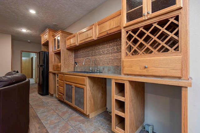 1108 N 18th Ave, Ozark, MO 65721 - kitchen featuring backsplash, a textured ceiling, glass insert cabinets, recessed lighting, and freestanding refrigerator