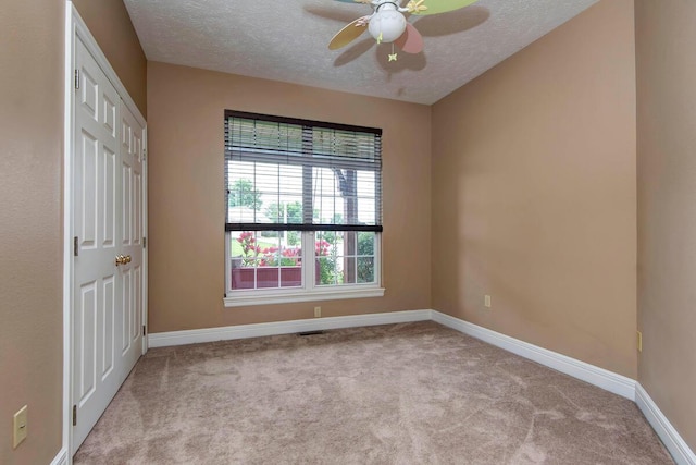 1108 N 18th Ave, Ozark, MO 65721 - unfurnished bedroom with a textured ceiling, carpet, a closet, and a ceiling fan