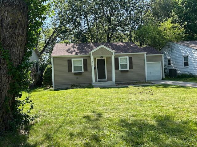 1033 S Crutcher Ave, Springfield, MO 65802 - view of front of home with a garage, a front lawn, and concrete driveway