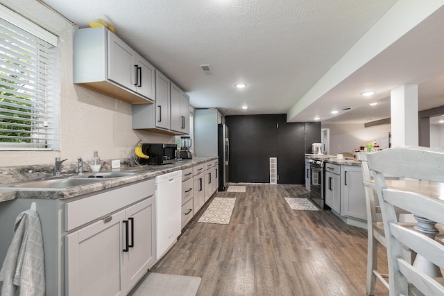 2225 N Plainview Ave, Springfield, MO 65803 - kitchen featuring appliances with stainless steel finishes, wood finished floors, light countertops, recessed lighting, and gray cabinets