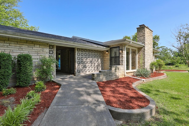 2225 N Plainview Ave, Springfield, MO 65803 - doorway to property with a chimney, a yard, stone siding, and a shingled roof