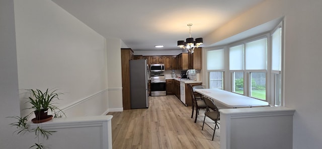2782 W Swan St, Springfield, MO 65807 - kitchen with appliances with stainless steel finishes, a chandelier, light countertops, light wood-style floors, and hanging light fixtures