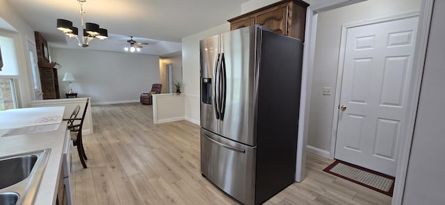 2782 W Swan St, Springfield, MO 65807 - kitchen with stainless steel fridge with ice dispenser, a chandelier, light wood-style flooring, dark brown cabinets, and hanging light fixtures