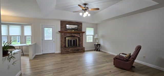 2782 W Swan St, Springfield, MO 65807 - living room with a tray ceiling, ceiling fan, a fireplace, and light wood-type flooring