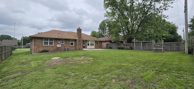 2782 W Swan St, Springfield, MO 65807 - back of house featuring brick siding, a chimney, a fenced backyard, and a patio area