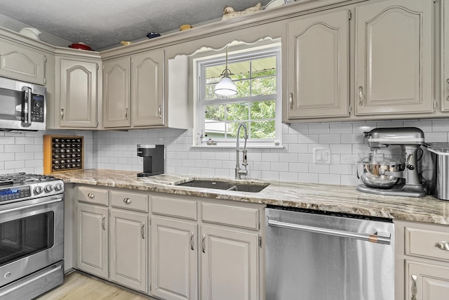 11996 N Farm Rd Unit 119, Brighton, MO 65617 - kitchen with appliances with stainless steel finishes, tasteful backsplash, light stone countertops, a textured ceiling, and light wood-type flooring