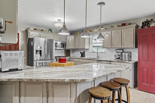 11996 N Farm Rd Unit 119, Brighton, MO 65617 - kitchen with appliances with stainless steel finishes, a peninsula, decorative backsplash, light wood-type flooring, and decorative light fixtures