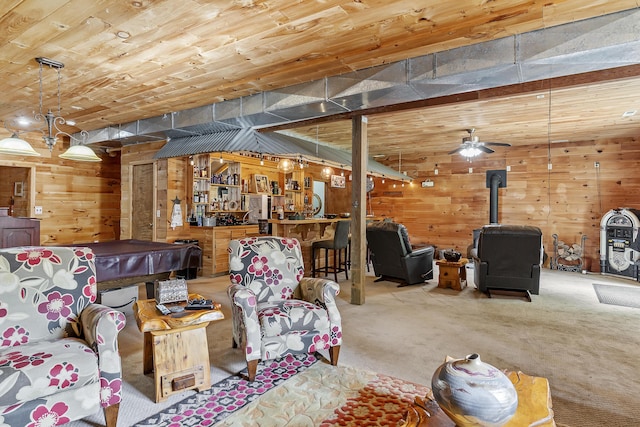 11996 N Farm Rd Unit 119, Brighton, MO 65617 - living room featuring a wood stove, wooden walls, carpet floors, wood ceiling, and ceiling fan