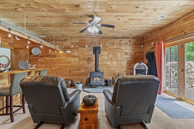 11996 N Farm Rd Unit 119, Brighton, MO 65617 - carpeted living area featuring a wood stove, wooden ceiling, wooden walls, and a ceiling fan