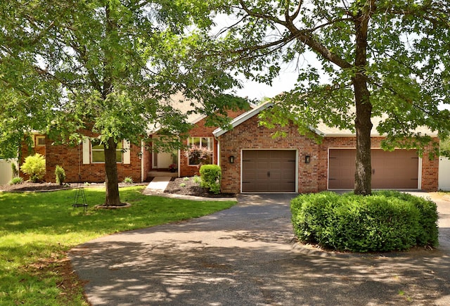 185 Tanner Rd, Branson, MO 65616 - view of front of home with driveway, an attached garage, brick siding, and a front lawn