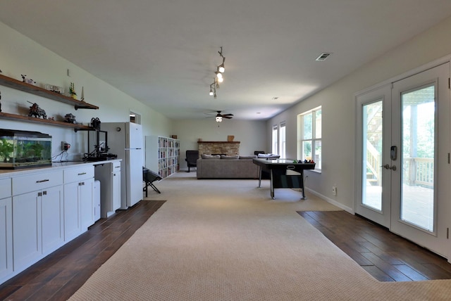 185 Tanner Rd, Branson, MO 65616 - interior space with ceiling fan, french doors, a stone fireplace, dark wood finished floors, and white cabinets