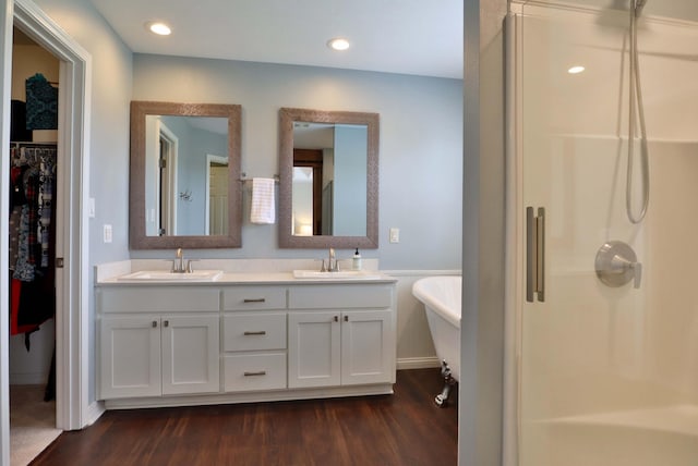 185 Tanner Rd, Branson, MO 65616 - bathroom featuring wood finished floors, double vanity, a freestanding bath, a shower, and a walk in closet