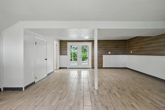 14289 Bethel Rd, Seneca, MO 64865 - unfurnished living room featuring light wood-style flooring, french doors, and wood walls