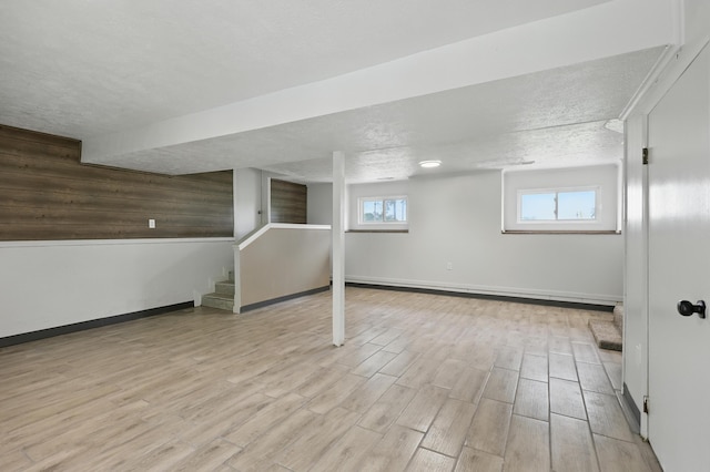 14289 Bethel Rd, Seneca, MO 64865 - basement featuring stairs, light wood-type flooring, and a textured ceiling