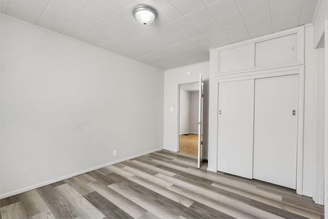 825 W Nichols St, Springfield, MO 65802 - unfurnished bedroom featuring light wood-style flooring, a closet, and ornamental molding