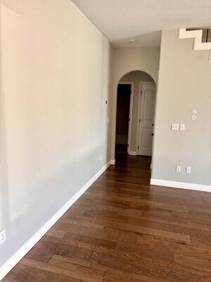 201 Sparrow Ln, Willard, MO 65781 - empty room featuring arched walkways and dark wood-style floors
