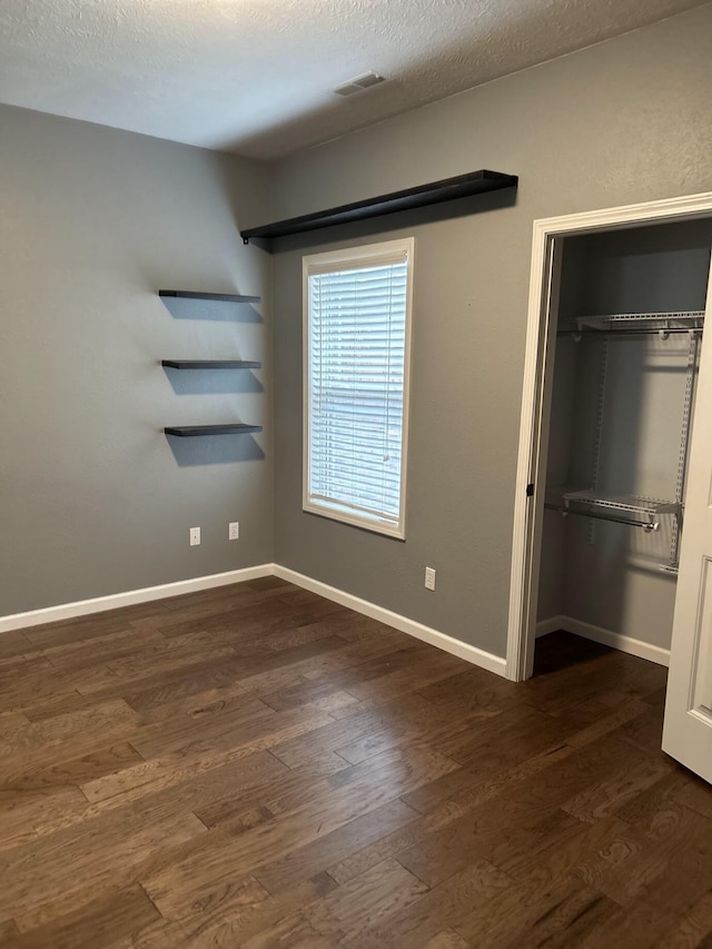 201 Sparrow Ln, Willard, MO 65781 - unfurnished bedroom with dark wood-style floors, a closet, a textured ceiling, and a spacious closet