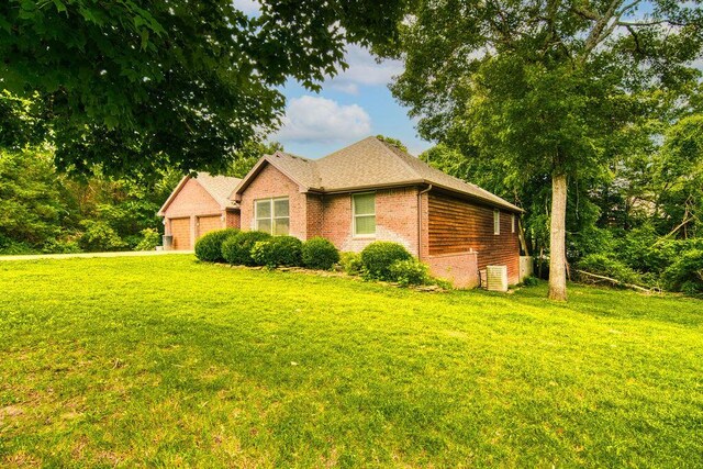 147 River Bluff Dr, Branson, MO 65616 - view of side of home with brick siding, a lawn, and a garage