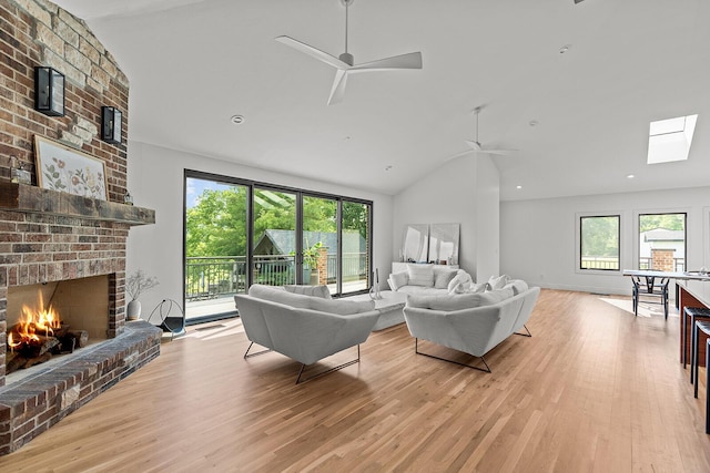 621 S Woodhaven Rd, Nixa, MO 65714 - living area with a ceiling fan, light wood-style flooring, a fireplace, a skylight, and high vaulted ceiling