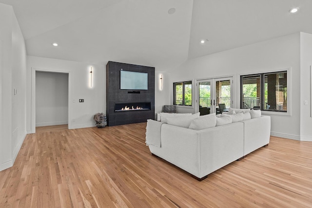 621 S Woodhaven Rd, Nixa, MO 65714 - living room featuring a tiled fireplace, high vaulted ceiling, light wood-style floors, and recessed lighting