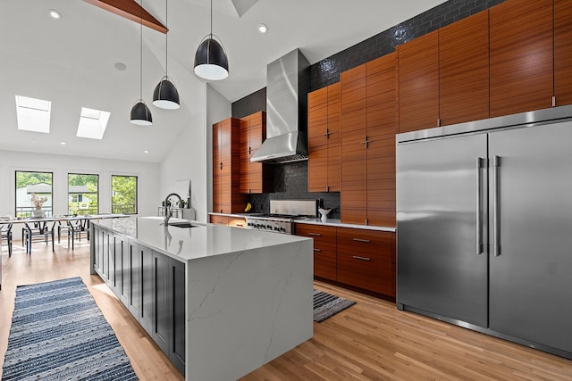 621 S Woodhaven Rd, Nixa, MO 65714 - kitchen with stainless steel built in fridge, wall chimney exhaust hood, a skylight, tasteful backsplash, and light wood-style floors