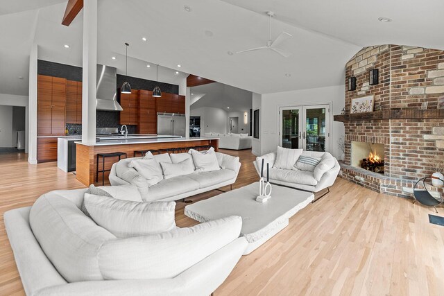 621 S Woodhaven Rd, Nixa, MO 65714 - living room with light wood-style floors, lofted ceiling, and a brick fireplace