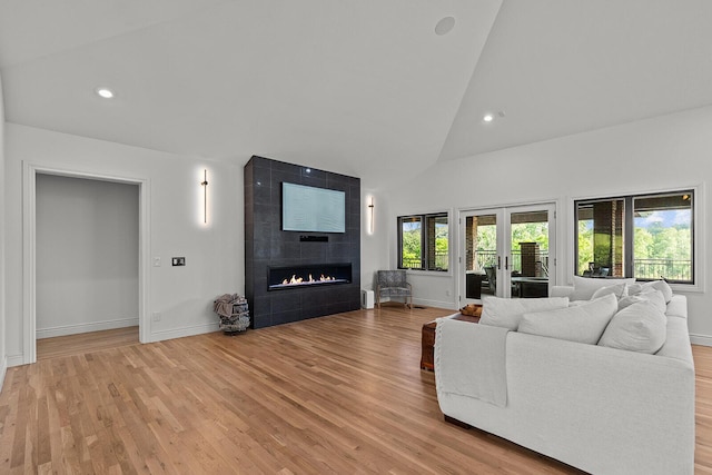 621 S Woodhaven Rd, Nixa, MO 65714 - living area with high vaulted ceiling, light wood-style flooring, french doors, a tile fireplace, and recessed lighting