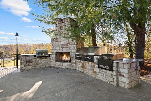 621 S Woodhaven Rd, Nixa, MO 65714 - view of patio featuring an outdoor kitchen and an outdoor stone fireplace