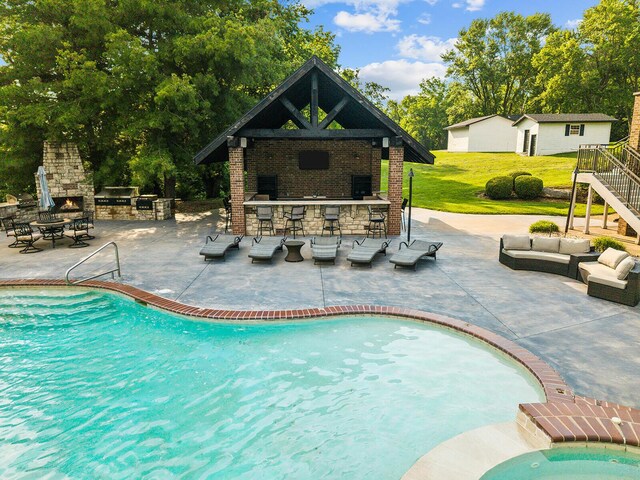 621 S Woodhaven Rd, Nixa, MO 65714 - swimming pool featuring an outdoor living space with a fireplace, a bar, a gazebo, a patio area, and view of scattered trees