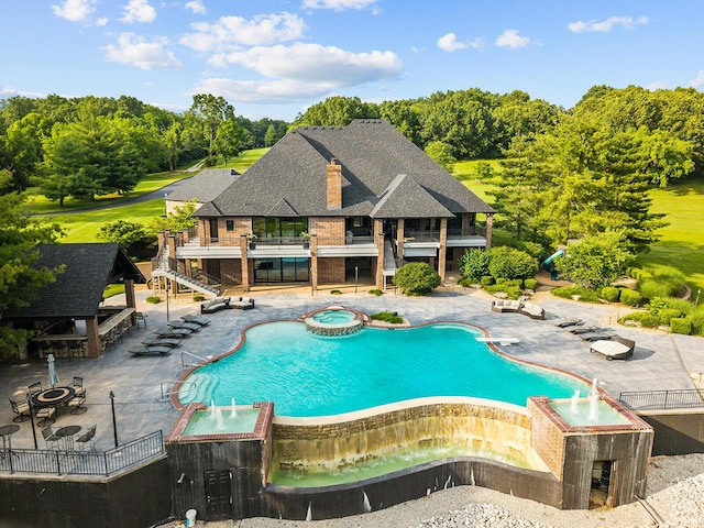 621 S Woodhaven Rd, Nixa, MO 65714 - view of swimming pool with a pool with connected hot tub, stairway, a patio area, and view of wooded area