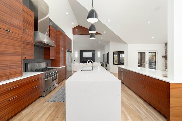 621 S Woodhaven Rd, Nixa, MO 65714 - kitchen with premium appliances, modern cabinets, wall chimney range hood, light wood-style flooring, and high vaulted ceiling