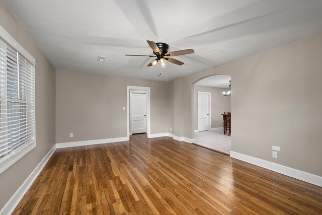 621 S Woodhaven Rd, Nixa, MO 65714 - unfurnished room featuring arched walkways, hardwood / wood-style floors, a ceiling fan, and a chandelier