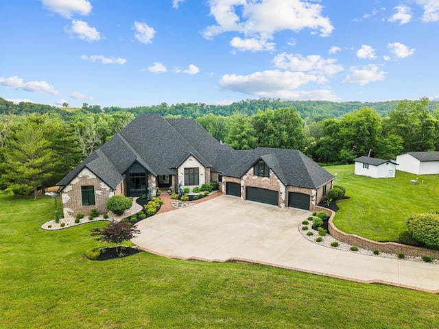 621 S Woodhaven Rd, Nixa, MO 65714 - french country home with stone siding, an attached garage, a front lawn, and driveway