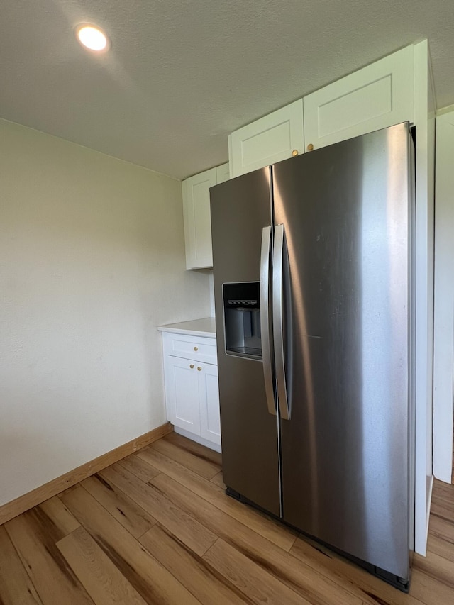 2191 County Road 2790, Mountain View, MO 65548 - kitchen with stainless steel fridge, light wood-type flooring, white cabinets, and light countertops