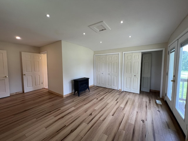 2191 County Road 2790, Mountain View, MO 65548 - unfurnished bedroom with a wood stove, multiple closets, wood finished floors, and recessed lighting