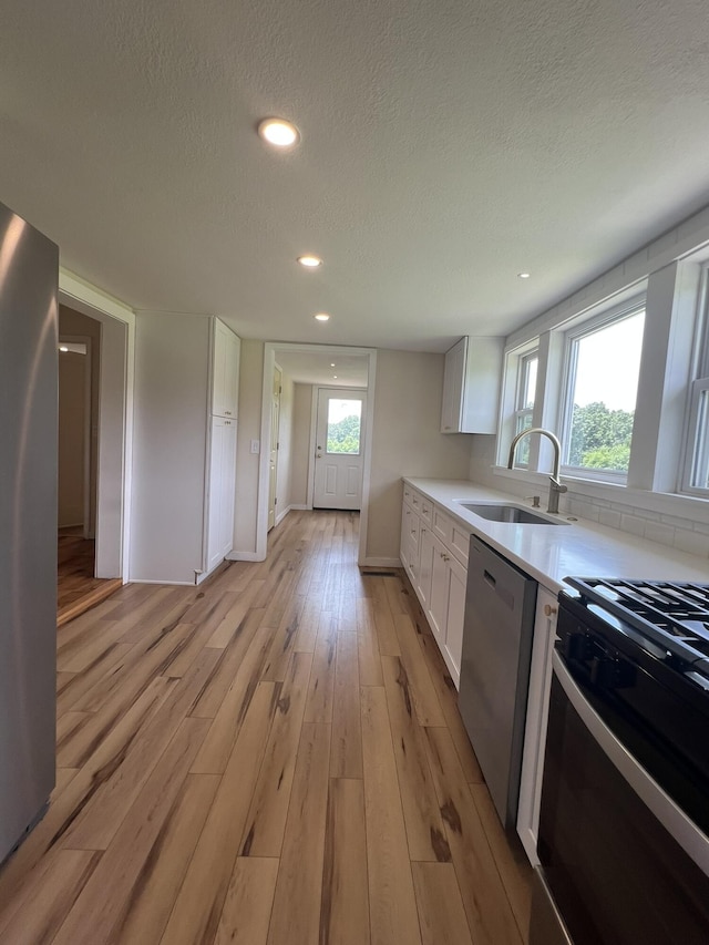 2191 County Road 2790, Mountain View, MO 65548 - kitchen featuring stainless steel appliances, light wood-style floors, white cabinets, a textured ceiling, and light countertops