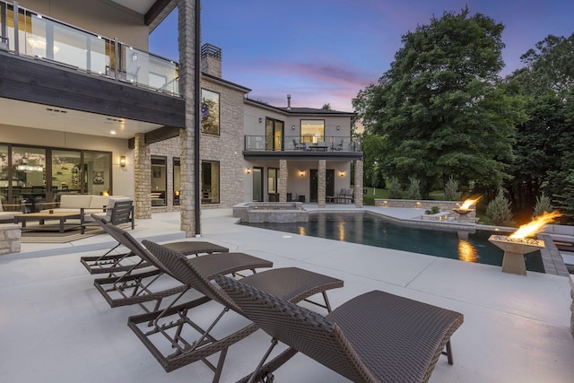 5817 E Summit View Dr, Springfield, MO 65809 - pool at dusk with an outdoor living space with a fire pit, a patio area, and a pool with connected hot tub