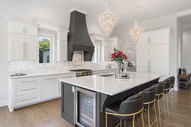 5817 E Summit View Dr, Springfield, MO 65809 - kitchen featuring wine cooler, a chandelier, custom range hood, decorative backsplash, and white cabinets