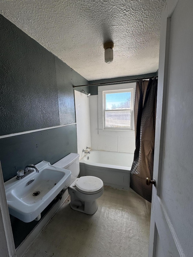 201 W Pennington Ave, Ava, MO 65608 - bathroom featuring a textured ceiling, shower / bath combo with shower curtain, a textured wall, and tile patterned floors