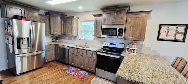 524 Niangua Rd, Niangua, MO 65713 - kitchen featuring appliances with stainless steel finishes, tasteful backsplash, light wood-style floors, a peninsula, and recessed lighting