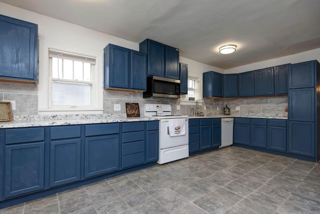 1612 N Grant Ave, Springfield, MO 65803 - kitchen featuring white appliances, blue cabinetry, tasteful backsplash, and stone finish flooring