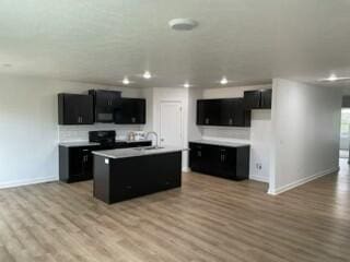 608 N Cheyenne Valley Rd, Nixa, MO 65714 - kitchen featuring dark cabinetry, recessed lighting, light wood-style flooring, and open floor plan