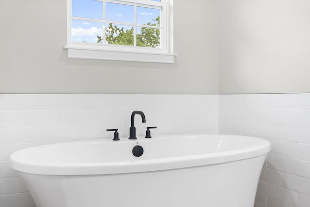427 N Maynard Rd, Nixa, MO 65714 - bathroom with tile walls, a soaking tub, and wainscoting